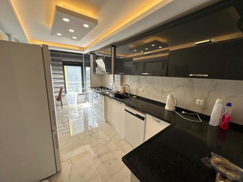 a large kitchen with black countertops and a large room at YUNUSELİ 7+2 VİLLA LUXURY in Yunuseli