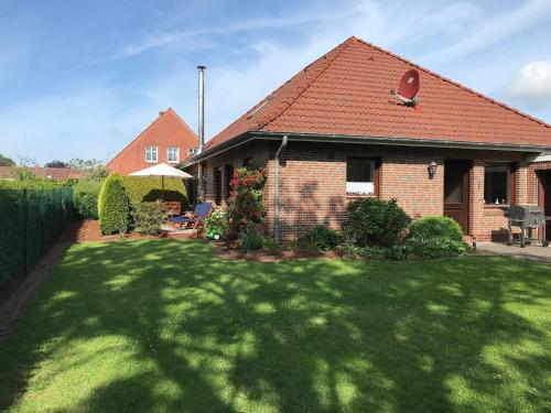 a brick house with a lawn in front of it at Liebevoll eingerichtetes ebenerdiges Haus mit Charme und Seele und wunderschönem Garten in Hage