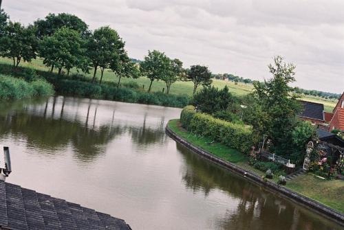 eine Luftansicht auf einen Fluss mit Bäumen und Häusern in der Unterkunft Ferienwohnung für 6 Personen ca 95 m in Emden, Nordseeküste Deutschland Ostfriesland in Emden