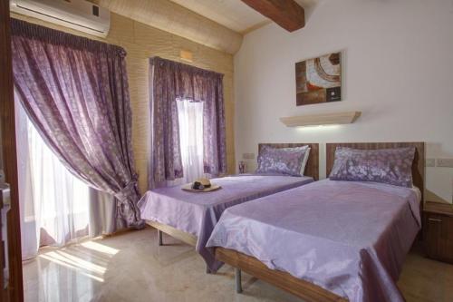 Un dormitorio con dos camas y una ventana. en Villa Cara, en Għarb