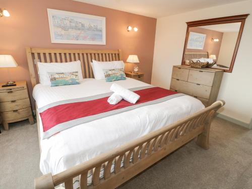 a bedroom with a bed with a teddy bear on it at Bryn Goleu in Moelfre