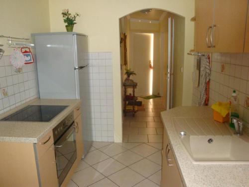 La cuisine est équipée d'un réfrigérateur et d'un évier. dans l'établissement Appartement in Ueckermünde mit Grill, à Ueckermünde
