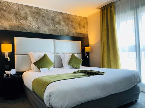 ein großes Bett in einem Hotelzimmer mit einem großen Fenster in der Unterkunft Best Western Allegro Nation in Paris