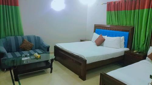 1 dormitorio con 2 camas, sofá y silla en Overseas B&B Guest House, en Islamabad