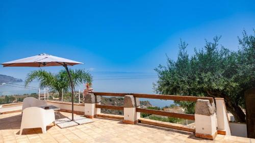 um pátio com uma cadeira e um guarda-sol e o oceano em Gästezimmer für 2 Personen ca 20 qm in Taormina, Sizilien Ostküste von Sizilien em Taormina