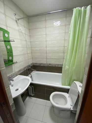 a bathroom with a toilet and a sink and a tub at Dimm Отель in Almaty