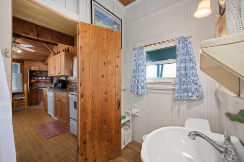 a bathroom with a sink and a kitchen at NH222 Island Dancer in Nags Head