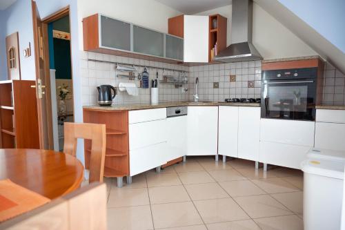 uma cozinha com armários brancos e uma mesa de madeira em Kamień Pomorski Homely House em Kamień Pomorski