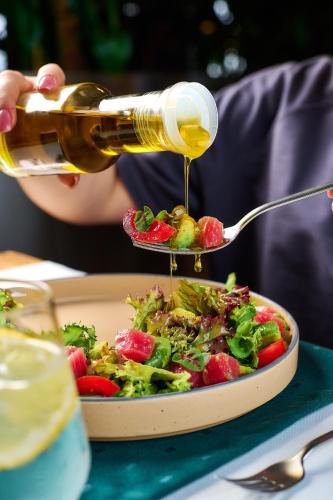 a person pouring sauce on a plate of food at Loft7 in Lviv