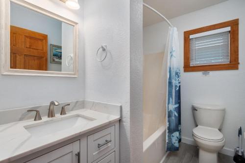 a bathroom with a sink and a toilet and a mirror at KH195 Just Wright in Kitty Hawk