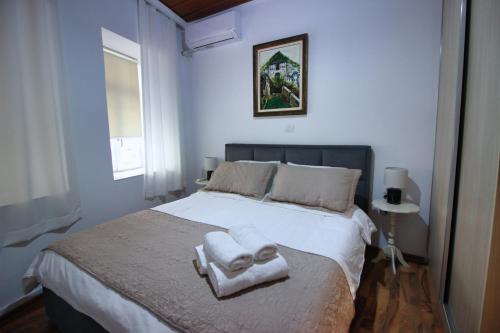 a bedroom with a bed with towels on it at Emblematic House Apartment 1 in Gjirokastër
