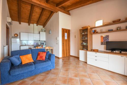 Il comprend un salon avec un canapé bleu et une cuisine. dans l'établissement Ferienwohnung in Moniga Del Garda mit gemeinsamem Pool und Garten und Seeblick, à Moniga del Garda