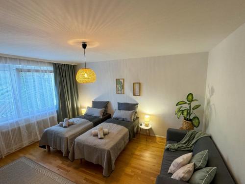 sala de estar con 2 camas y sofá en revLIVING Kaiser Franz Septima Altstadt Apartment Baden, en Baden