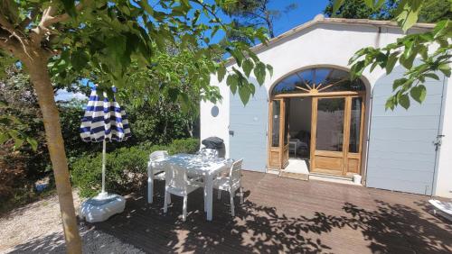 une table et un parasol sur une terrasse en bois dans l'établissement Maison Clair de Lune, à Cabasse