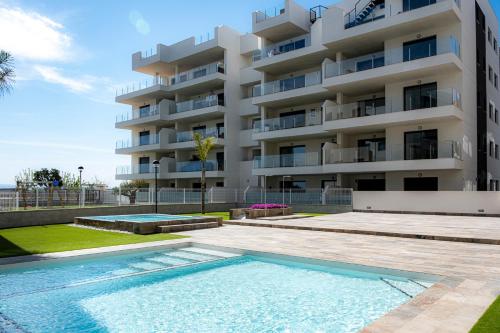 a building with a swimming pool in front of a building at Casa Velapi - 2 Bedroom apartment in Los Alcázares