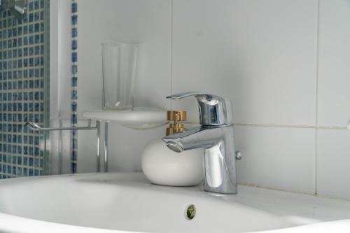 lavabo con grifo y taza en Lovely Penthouse in Gzira, en Il-Gżira