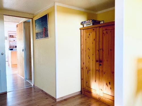 a room with a wooden cabinet and a hallway at Ferienhaus Balu mit eigenem Steig direkt am Wasser IJsselmeer in Wervershoof