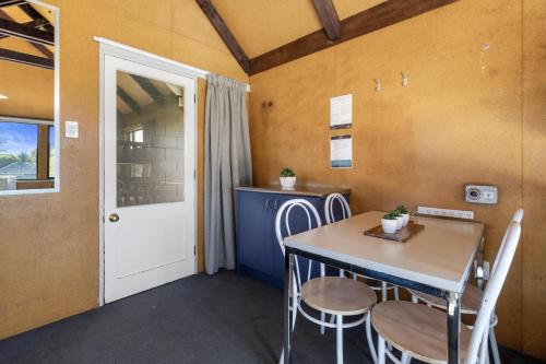 a dining room with a table and chairs and a door at Tasman Holiday Parks - Christchurch in Christchurch