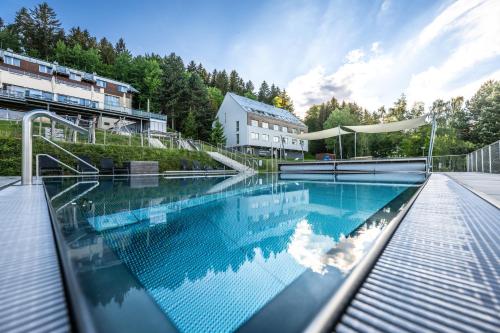 a large swimming pool in front of a building at Hotel Monínec - Depandance Nová Javorka in Moninec
