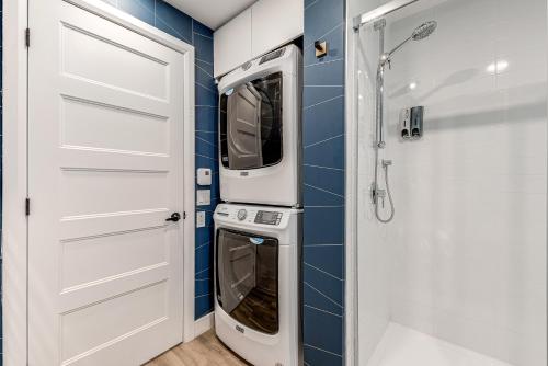 uma casa de banho com 2 máquinas de lavar roupa e um chuveiro em Le Dark Luxury nice view and rooftop pool em Cidade de Quebec
