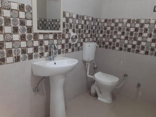 a bathroom with a sink and a toilet at RESIDENCE TULSI in Vrindāvan