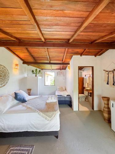 sypialnia z 2 łóżkami i drewnianym sufitem w obiekcie Atins Beach Houses w mieście Atins