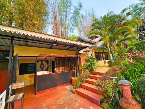 a house with a staircase leading to a patio at Phu Jaya Floresta Resort by ALPHATEL PARTNER in Chiang Mai