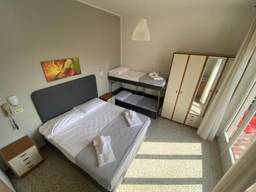 a small bedroom with a bed and a mirror at Hotel Ausonia in Rimini