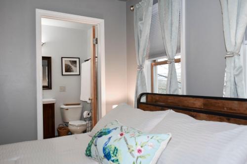a bedroom with a bed and a bathroom with a toilet at River Front In The Heart Of Ithaca in Ithaca