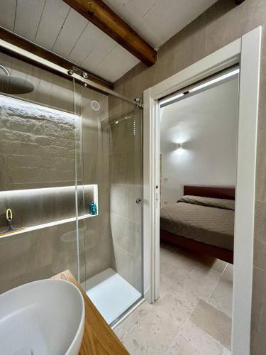 a bathroom with a shower and a sink and a bed at Blu Marina Apartment in Giovinazzo