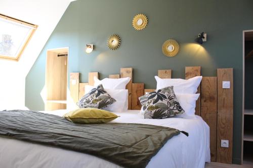 a bedroom with a large bed with two mirrors on the wall at La Chaumière - Nature et SPA privé in Béganne