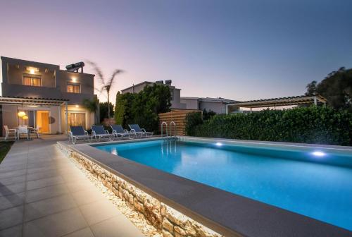 a swimming pool in front of a house at Sea Homes Villas- Villa Alberto in Kiotari