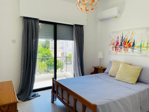 ein Schlafzimmer mit einem Bett und einem großen Fenster in der Unterkunft Moments Together in Oroklini