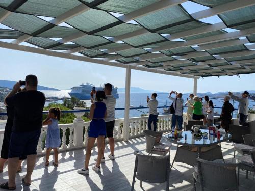 a group of people standing on a balcony looking at the ocean at İZAN VİLLA BAKIŞ APARTMENTS in Bodrum City