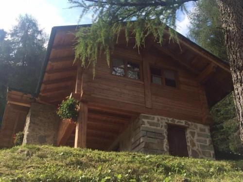 ein Blockhaus mit einem Baum davor in der Unterkunft Ferienhaus in Pieve Di Bono mit Grill, Garten und Sauna in Pieve di Bono