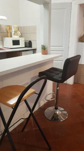 une chaise noire assise devant un comptoir de cuisine dans l'établissement Le Verdini, à Carcassonne