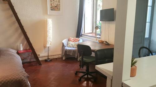 Cette chambre comprend une table et une chaise. dans l'établissement Le Verdini, à Carcassonne