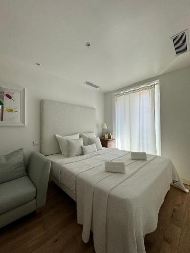 - une chambre blanche avec un grand lit et un canapé dans l'établissement Venue C - Luxurious & Spacious - Mansion - Elevator - Patio, à Cannes
