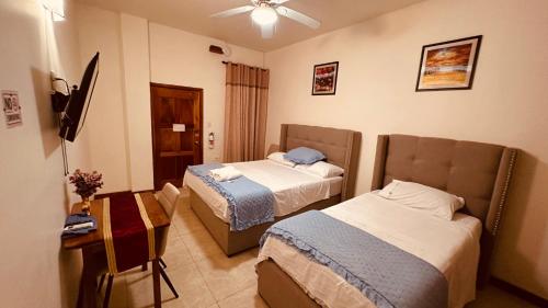 a hotel room with two beds and a desk at San Pedro Ocean Paradise in San Pedro