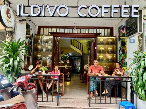 a group of people sitting at tables outside a coffee shop at Old Quarter Autumn To Tich Ha Noi in Hanoi