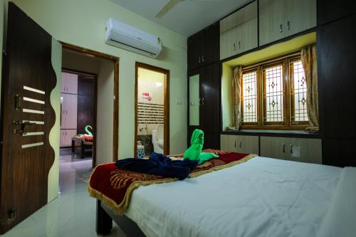 a bedroom with a bed with a green object on it at S V IDEAL HOMESTAY -2BHK SERVICE APARTMENTS-AC Bedrooms, Premium Amities, Near to Airport in Tirupati