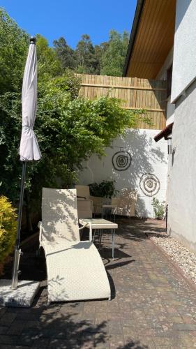 a patio with an umbrella and a chair and a bench at Beas Ferienglück in Busenberg