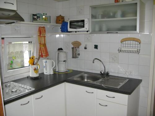a kitchen with a sink and a counter top at Chalet direkt an der Gracht mit eigenem Bootsanlegesteiger in Wervershoof