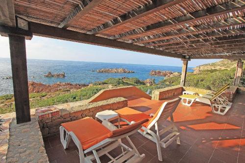 een patio met stoelen en uitzicht op de oceaan bij Ferienhaus in Costa Paradiso mit Grill, Terrasse und Garten in Costa Paradiso