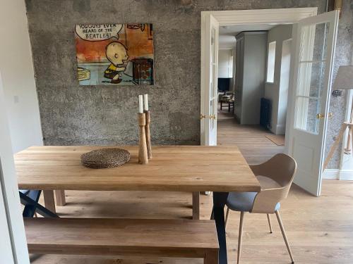 una mesa de madera en una habitación con una pintura en la pared en The stables en Kildare