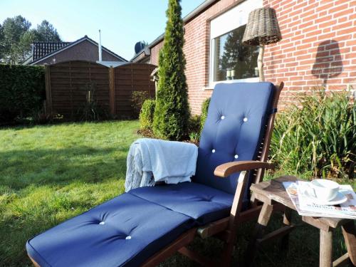 einem blauen Stuhl, der in einem Garten neben einem Tisch sitzt in der Unterkunft Ferienhaus für 2 Personen ca 56 m in Hage, Nordseeküste Deutschland Ostfriesland in Hage