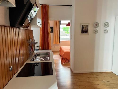 a kitchen with a sink and a room with a bed at Casa Luna 6 min Hbf , Erdgeschosswohnung ,Altbau in Duisburg