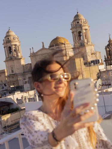 a woman taking a picture of a church at Candelaria10 in Cádiz