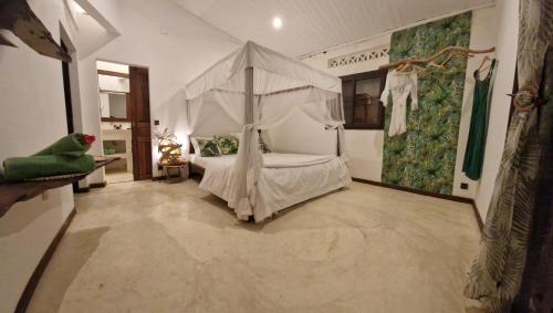 a bedroom with a bed with a canopy at La Villa Ankarena Location de villa entière avec piscine privée à débordement sur parc aménagé Wifi TV Plage à 5 minutes à pied in Sainte Marie