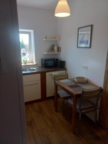 a kitchen with a table and a small table and chairs at Na Rogu in Lębork